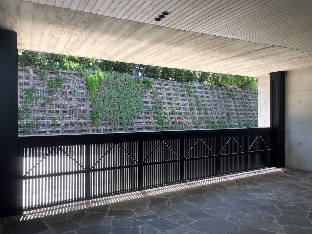 Uplift Garage Door overlooking retaining wall with vines and flowers