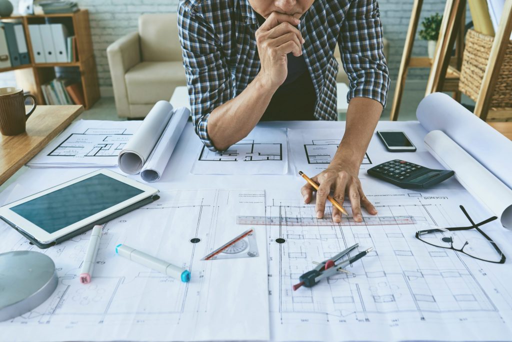 Cropped image of architect working with construction plans