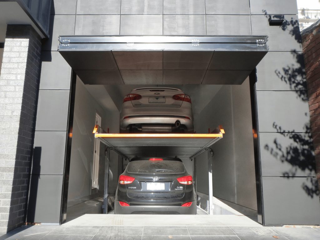 Flush Finish Folding Facade Garage Door open showing two cars on a car stacker