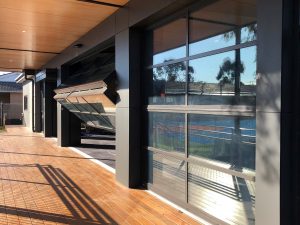 A Wooden Deck on a sunny day with Folding Doors opening up