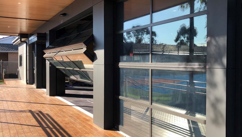 A Wooden Deck on a sunny day with Folding Doors opening up