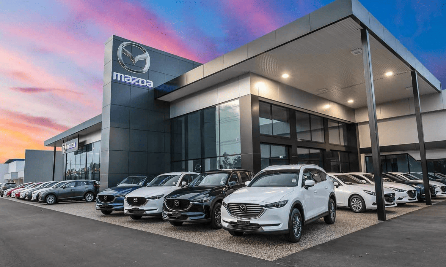 a car yard owned by Mazda in the setting sun, featuring a distinct folding door