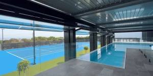 5 folding windows open, viewing the tennis courts and beautiful scene from the infinity pool