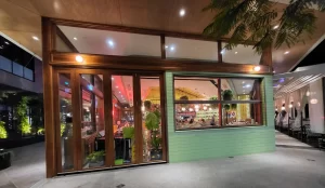A sophisticated dining setting at Spice Market Thai restaurant in Karrinyup, WA, featuring Smartech's Folding Windows with a rich wood-grain appearance, seamlessly blending with the venue's timber aesthetics and providing a functional, open-air ambience.