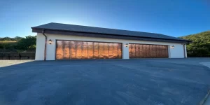 two garage doors clad in copper sheeting glistening in the sun.